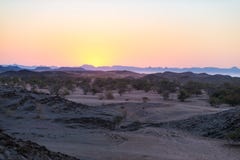 Красочный заход солнца над пустыней Namib, Намибия, Африка Горы, дюны и деревья акации силуэт в backlight Clea оранжевого красног стоковое изображение Красочный заход солнца над пустыней Namib, Намибия, Африка Горы, дюны и деревья акации силуэт в backlight Clea оранжевого красног стоковое изображение