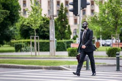 Крест бизнесмена улица внешняя носящ маску противогаза на стороне стоковое изображение rf Крест бизнесмена улица внешняя носящ маску противогаза на стороне стоковое изображение rf