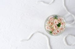 Круглый сосуд с водой и небольшими розами персика стоковые изображения Круглый сосуд с водой и небольшими розами персика стоковые изображения