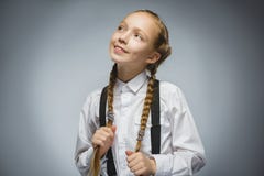 Крупный план мечтая маленькая девочка смотря вверх против серой предпосылки Стоковые Фотографии RF Крупный план мечтая маленькая девочка смотря вверх против серой предпосылки Стоковые Фотографии RF