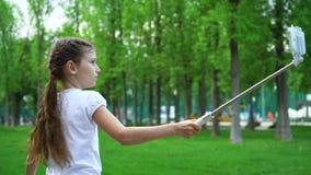 Крупный план беспечальных маленьких девочек делая ролики selfies катаясь на коньках в outdoo парка стоковые фотографии rf Крупный план беспечальных маленьких девочек делая ролики selfies катаясь на коньках в outdoo парка стоковые фотографии rf