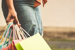 Крупный план женщины держа хозяйственную сумку бумаги цвета на улице сумма стоковые фото Крупный план женщины держа хозяйственную сумку бумаги цвета на улице сумма стоковые фото