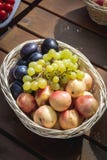 Крупный план корзины с виноградинами, персиками и выступать на деревянном столе, внешней партии или пикнике, взгляд сверху стоковое изображение rf Крупный план корзины с виноградинами, персиками и выступать на деревянном столе, внешней партии или пикнике, взгляд сверху стоковое изображение rf