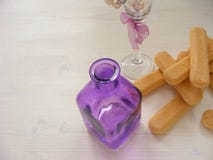 Крупный план много печений Savoiardi с фиолетовыми бутылкой и стеклом на винтажной белой таблице с космосом экземпляра стоковые фото Крупный план много печений Savoiardi с фиолетовыми бутылкой и стеклом на винтажной белой таблице с космосом экземпляра стоковые фото