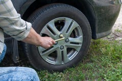 Крупный план мужских рук используя ключ для автошины автомобиля Замена колеса после аварии в солнечном дне Ow ремонта автомобиля стоковая фотография Крупный план мужских рук используя ключ для автошины автомобиля Замена колеса после аварии в солнечном дне Ow ремонта автомобиля стоковая фотография