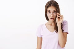Крытая съемка впечатленного удивленного привлекательного брюнет взрослой женщины принимая стекла и падая брови повышения челюсти стоковые изображения rf Крытая съемка впечатленного удивленного привлекательного брюнет взрослой женщины принимая стекла и падая брови повышения челюсти стоковые изображения rf