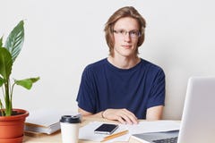Крытое изображение талантливого профессионального мужского работника офиса с ультрамодным стилем причёсок, носит зрелища и футбол стоковое фото Крытое изображение талантливого профессионального мужского работника офиса с ультрамодным стилем причёсок, носит зрелища и футбол стоковое фото