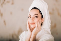 Купальный халат и полотенце привлекательной девушки нося белый на голове в bathroom стоковое изображение rf Купальный халат и полотенце привлекательной девушки нося белый на голове в bathroom стоковое изображение rf