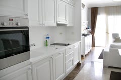 Кухня бела с белыми кухонными шкафами, плитой, холодильником, раковиной Белая комната афоризма стоковое фото Кухня бела с белыми кухонными шкафами, плитой, холодильником, раковиной Белая комната афоризма стоковое фото