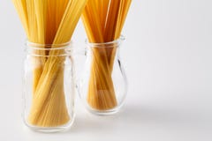 Куча сырых итальянских макаронных изделий в стеклянном опарнике на белизне с экземпляром s Стоковая Фотография RF Куча сырых итальянских макаронных изделий в стеклянном опарнике на белизне с экземпляром s Стоковая Фотография RF