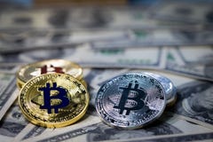 Куча штабелировать золотое bitcoin на 100 банкнотах доллара одиночная монетка смотря на камеру в остром фокусе стоковое фото rf Куча штабелировать золотое bitcoin на 100 банкнотах доллара одиночная монетка смотря на камеру в остром фокусе стоковое фото rf
