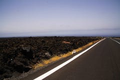 Лансароте - Timanfaya NP: Управлять отключением на бесконечной пустой дороге асфальта между черными утесами лавы в неурожайном ла стоковое изображение Лансароте - Timanfaya NP: Управлять отключением на бесконечной пустой дороге асфальта между черными утесами лавы в неурожайном ла стоковое изображение