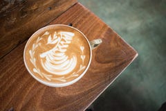 Лебедь искусства latte чашки кофе в угле деревянного стола стоковая фотография Лебедь искусства latte чашки кофе в угле деревянного стола стоковая фотография