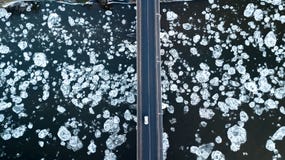 Ледяные поля плавая на реку Мост реки Взгляд глаза ` s птицы стоковая фотография rf Ледяные поля плавая на реку Мост реки Взгляд глаза ` s птицы стоковая фотография rf