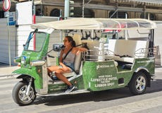 Лиссабон, Португалия - 5-ое августа 2017: Водитель маленькой девочки такси Tuk Tuk на дороге Лиссабона Португалии стоковое фото Лиссабон, Португалия - 5-ое августа 2017: Водитель маленькой девочки такси Tuk Tuk на дороге Лиссабона Португалии стоковое фото