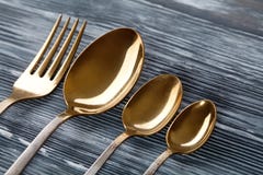 Ложки и вилка золота на серой деревянной предпосылке винтажный tableware с царапинами царапин сфокусируйте мягко Взгляд макроса стоковая фотография Ложки и вилка золота на серой деревянной предпосылке винтажный tableware с царапинами царапин сфокусируйте мягко Взгляд макроса стоковая фотография
