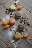 Ложь Macarons пестротканая на деревянном столе с различными ингредиентами, шоколадом, кофе, tangerines и больше стоковое фото rf Ложь Macarons пестротканая на деревянном столе с различными ингредиентами, шоколадом, кофе, tangerines и больше стоковое фото rf