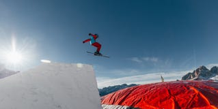 Лыжник скача на брыкунью, посадку воздушного шара, парк снега Val di Fassa Dolomiti стоковые изображения Лыжник скача на брыкунью, посадку воздушного шара, парк снега Val di Fassa Dolomiti стоковые изображения