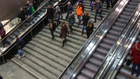 Люди на эскалаторе и лестнице быстроподвижных вверх и вниз Люди на эскалаторе и лестнице быстроподвижных вверх и вниз