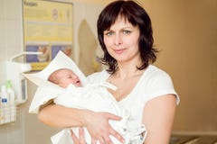 Любящая мать обнимая ее newborn младенца стоковая фотография rf Любящая мать обнимая ее newborn младенца стоковая фотография rf