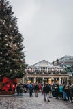 Люди идя гигантской рождественской елкой в рынке Ковент Гардена, Лондоне, Великобритании стоковая фотография Люди идя гигантской рождественской елкой в рынке Ковент Гардена, Лондоне, Великобритании стоковая фотография