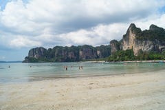 Люди наслаждаясь голубым небом и пляжем бирюзы с утесами в Krabi, Таиланде стоковое фото rf Люди наслаждаясь голубым небом и пляжем бирюзы с утесами в Krabi, Таиланде стоковое фото rf