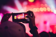 Люди наслаждаясь рок-концертом и принимая фото с сотовым телефоном a стоковые изображения Люди наслаждаясь рок-концертом и принимая фото с сотовым телефоном a стоковые изображения