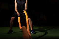Люди с сражением rope в функциональном спортзале фитнеса тренировки, людях фитнеса работая с веревочками сражения на спортзале стоковое изображение rf Люди с сражением rope в функциональном спортзале фитнеса тренировки, людях фитнеса работая с веревочками сражения на спортзале стоковое изображение rf