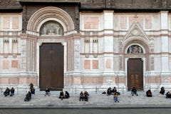 Люди сидя перед Сан Petronio Собором Базиликой di Сан Petronio в болонья стоковые изображения rf Люди сидя перед Сан Petronio Собором Базиликой di Сан Petronio в болонья стоковые изображения rf