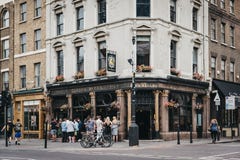 Люди стоя и выпивая вне паба 10 колоколов в Shoreditch, Лондоне, Великобритании стоковое фото rf Люди стоя и выпивая вне паба 10 колоколов в Shoreditch, Лондоне, Великобритании стоковое фото rf