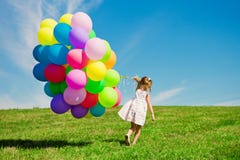Маленькая девочка держа красочные воздушные шары. Ребенок играя на зеленом цвете стоковые изображения Маленькая девочка держа красочные воздушные шары. Ребенок играя на зеленом цвете стоковые изображения