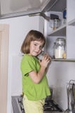 Маленькая девочка на стуле, который нужно достигнуть более высоко для того чтобы получить шоколады Стоковое Фото Маленькая девочка на стуле, который нужно достигнуть более высоко для того чтобы получить шоколады Стоковое Фото