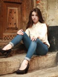Маленькая девочка сидя outdoors унылое, на предпосылке старый дом стоковая фотография rf Маленькая девочка сидя outdoors унылое, на предпосылке старый дом стоковая фотография rf