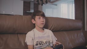 Мальчик играя видеоигры на консоли дальше софа дома акции видеоматериалы Мальчик играя видеоигры на консоли дальше софа дома акции видеоматериалы