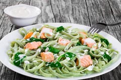 Макаронные изделия Fettuccine семг и шпината на белых блюдах стоковое изображение Макаронные изделия Fettuccine семг и шпината на белых блюдах стоковое изображение