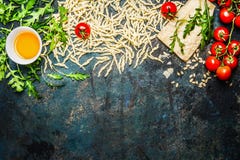 Макаронные изделия, томаты и ингридиенты для варить на деревенской предпосылке, взгляд сверху, границе стоковые изображения rf Макаронные изделия, томаты и ингридиенты для варить на деревенской предпосылке, взгляд сверху, границе стоковые изображения rf