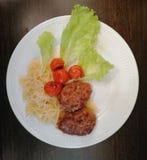 Макаронные изделия, котлеты, испеченные томаты и салат стоковое изображение rf Макаронные изделия, котлеты, испеченные томаты и салат стоковое изображение rf