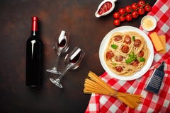 Макаронные изделия спагетти с фрикадельками, томатным соусом вишни, сыром, рюмкой и бутылкой на ржавой предпосылке стоковые фотографии rf Макаронные изделия спагетти с фрикадельками, томатным соусом вишни, сыром, рюмкой и бутылкой на ржавой предпосылке стоковые фотографии rf