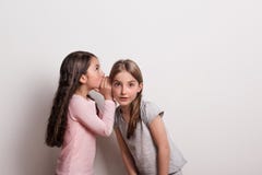 Малая девушка шепча что-то в ухе ее друга Стоковое фото RF Малая девушка шепча что-то в ухе ее друга Стоковое фото RF