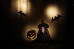 Маленькая ведьма сидит и испугана теней в форме тыквы и летучей мыши Концепция праздников хеллоуина стоковые изображения rf Маленькая ведьма сидит и испугана теней в форме тыквы и летучей мыши Концепция праздников хеллоуина стоковые изображения rf