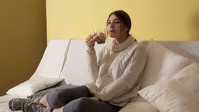 Маленькая девочка в уютном теплом свитере на зиме выравнивая дома выпивая чай и думая о что-то видеоматериал Маленькая девочка в уютном теплом свитере на зиме выравнивая дома выпивая чай и думая о что-то видеоматериал