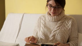 Маленькая девочка в уютном теплом свитере на зиме выравниваясь дома, кладущ на стекла читая книгу Зима Дом девушка акции видеоматериалы Маленькая девочка в уютном теплом свитере на зиме выравниваясь дома, кладущ на стекла читая книгу Зима Дом девушка акции видеоматериалы