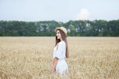 Маленькая девочка в шляпе лодочник наслаждаясь природой пшеничного поля Красивая девушка в белых бегах платья на поле на заходе с стоковое фото rf Маленькая девочка в шляпе лодочник наслаждаясь природой пшеничного поля Красивая девушка в белых бегах платья на поле на заходе с стоковое фото rf