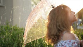 Маленькая девочка играя в дожде с зонтиком Ребенк Cutie имея Outdoors потехи видеоматериал Маленькая девочка играя в дожде с зонтиком Ребенк Cutie имея Outdoors потехи видеоматериал