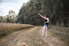 Маленькая девочка идя barefoot на том основании дорога через поле и лес, концепция лета и перемещение стоковые изображения Маленькая девочка идя barefoot на том основании дорога через поле и лес, концепция лета и перемещение стоковые изображения