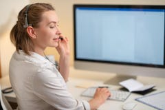 Маленькая девочка работает в центре телефонного обслуживания Для рабочего места с телефоном Микрофон с микрофоном Вспомогательное стоковые фотографии rf Маленькая девочка работает в центре телефонного обслуживания Для рабочего места с телефоном Микрофон с микрофоном Вспомогательное стоковые фотографии rf