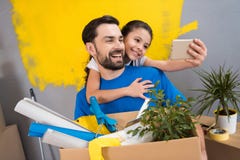 Маленькая дочь используя smartphone делает selfie с ее отцом который держит коробку инструментов и вещей стоковые изображения Маленькая дочь используя smartphone делает selfie с ее отцом который держит коробку инструментов и вещей стоковые изображения