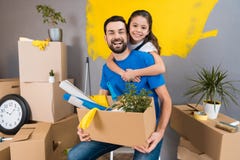 Маленькая дочь обнимает ее отца, который держит коробку инструментов и вещей Семья расквартировывает ремонты совместно стоковые фото Маленькая дочь обнимает ее отца, который держит коробку инструментов и вещей Семья расквартировывает ремонты совместно стоковые фото