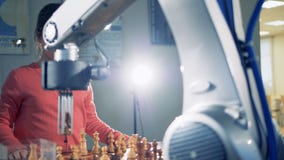 Маленькая темная с волосами девушка играет шахмат с робототехнической рукой сток-видео Маленькая темная с волосами девушка играет шахмат с робототехнической рукой сток-видео