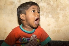 Маленький мальчик попрошайки от Индии стоя на streetside, плача для еды стоковые фото Маленький мальчик попрошайки от Индии стоя на streetside, плача для еды стоковые фото